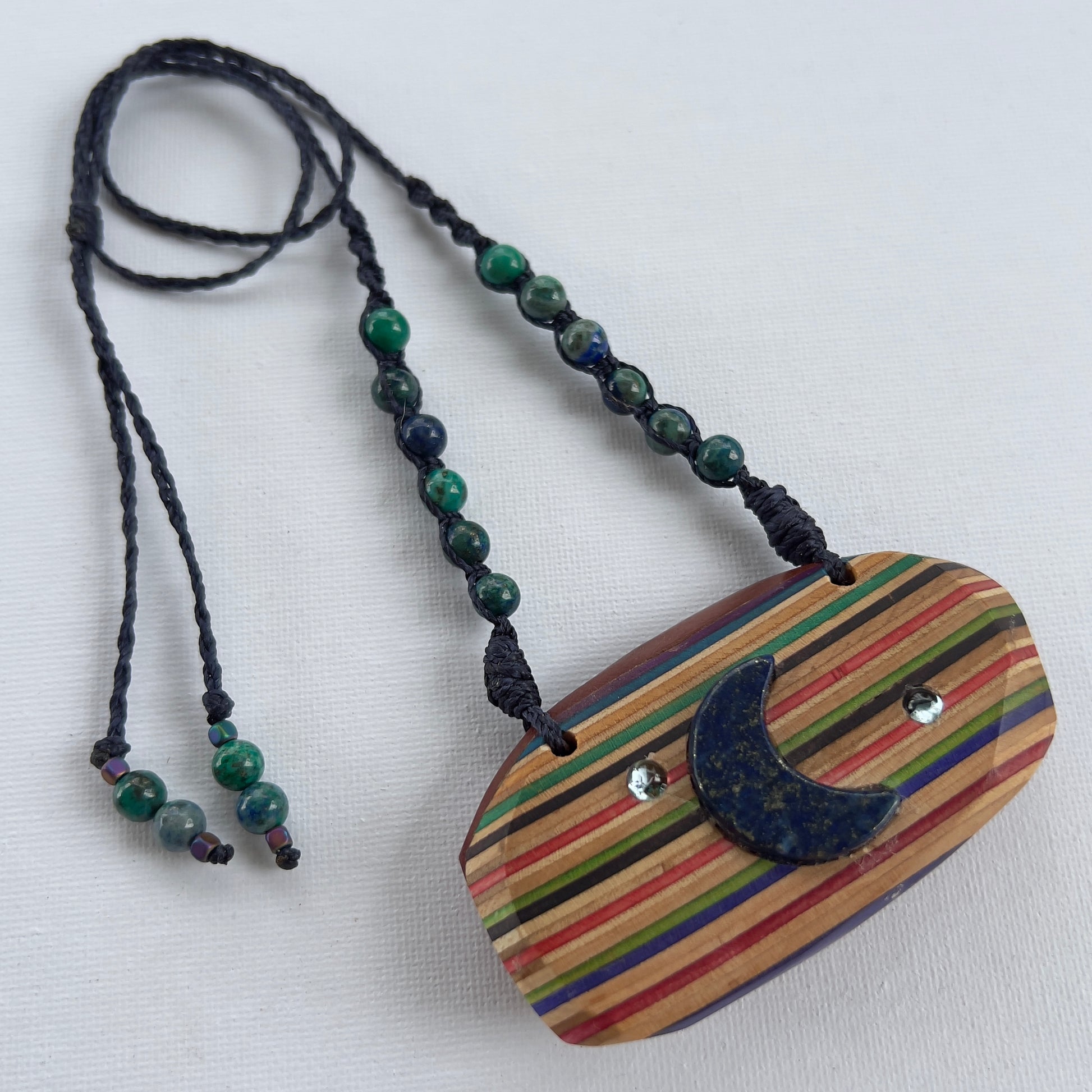 Handmade, unique recycled skateboard pendant with embedded Lapis Lazuli Moon and Topaz Stars on an adjustable macrame necklace cord woven with Azurite beading