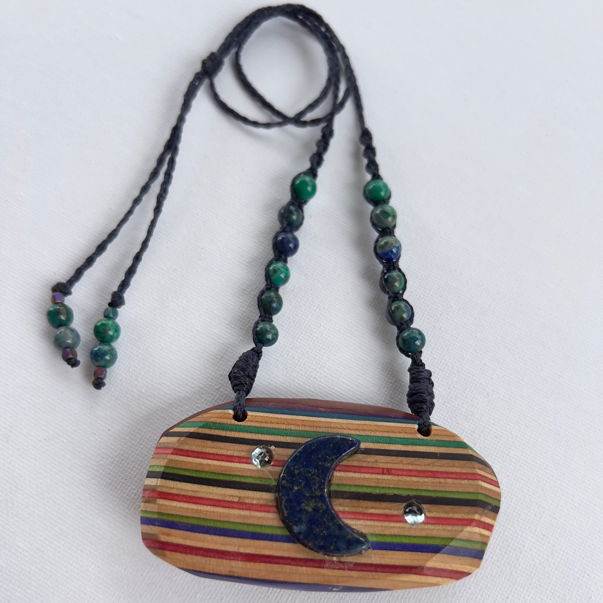 Handmade, unique recycled skateboard pendant with embedded Lapis Lazuli Moon and Topaz Stars on an adjustable macrame necklace cord woven with Azurite beading
