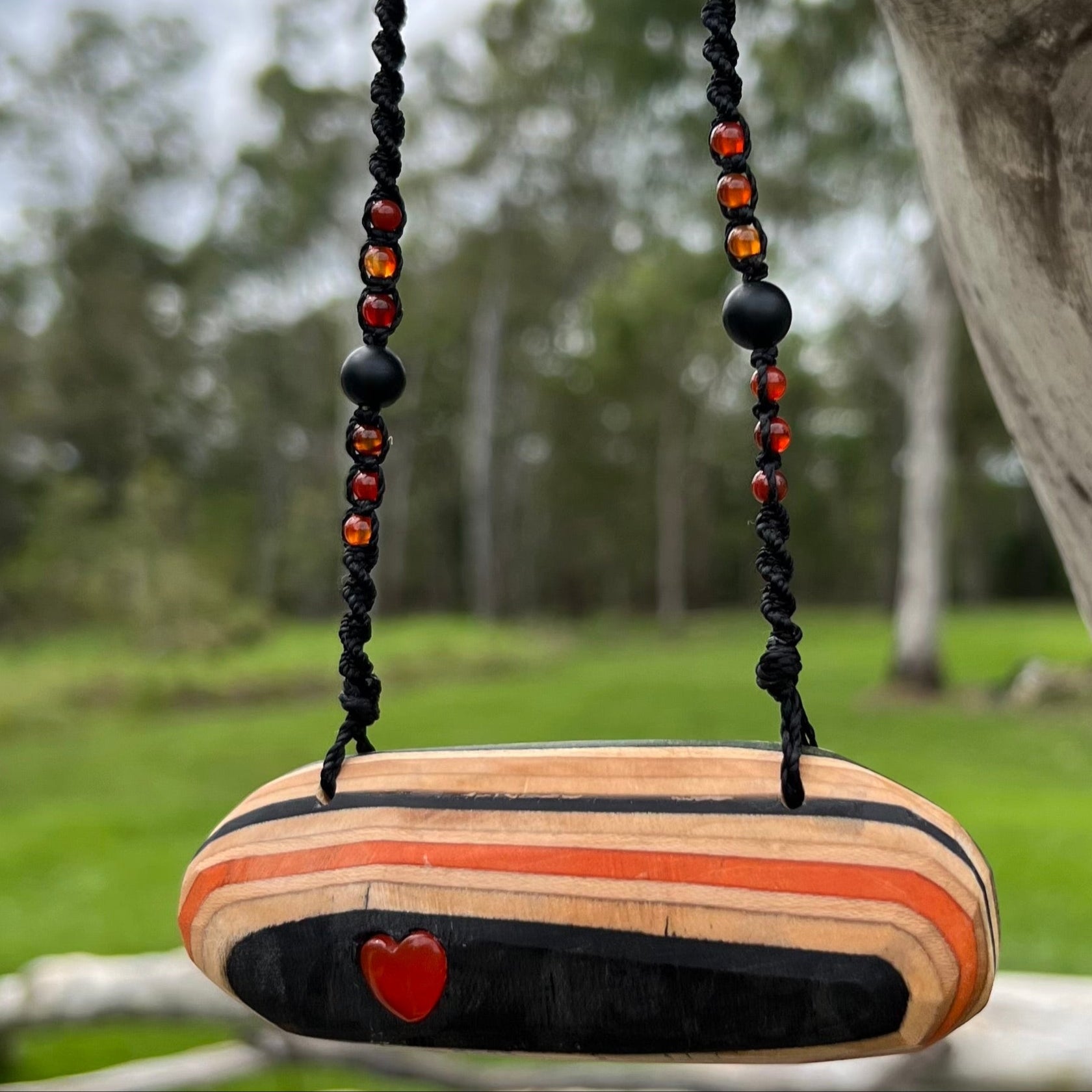 Handmade, unique recycled skateboard pendant with lush embedded Carnelian crystal heart on an adjustable macrame necklace cord woven with Obsidian and Carnelian.